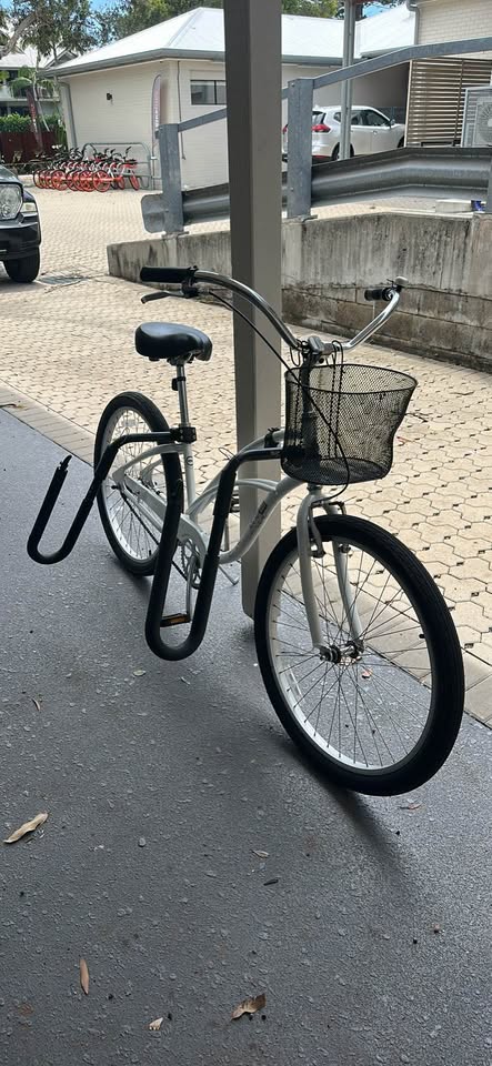 Actual BEAST longboard rack with two supports fitted to a white bicycle