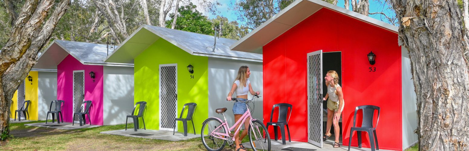 getting out of the colourful cabins ready to go for a bike ride in byron