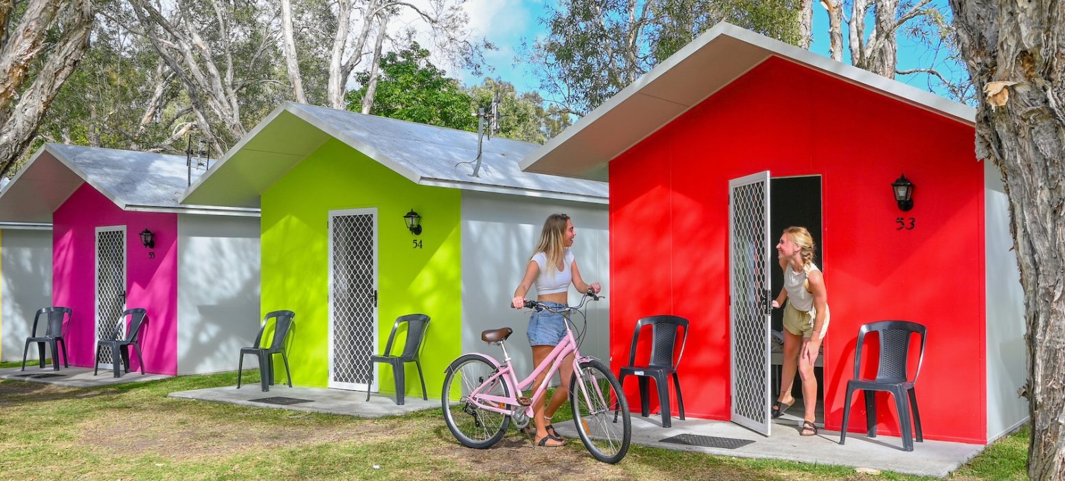 getting out of the colourful cabins ready to go for a bike ride in byron